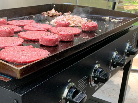 Blackstone Griddle from Walmart with hamburgers cooking on the griddle