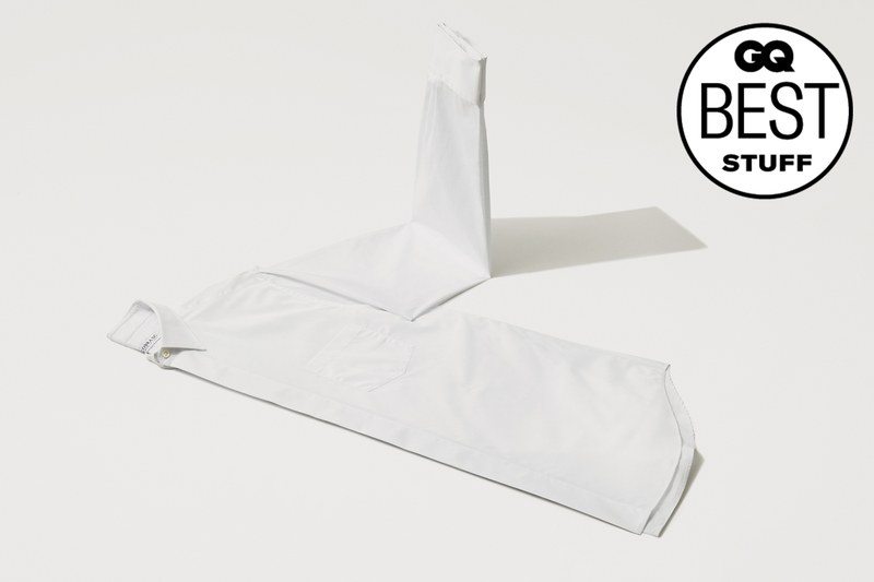 A white dress shirt laying on a white background, with it's arms folded up