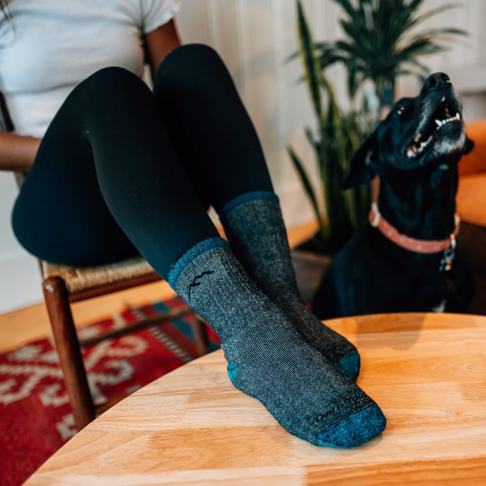 Valentine's Gift Guide - Woman with her feet up on the table wearing cozy mountaineering socks