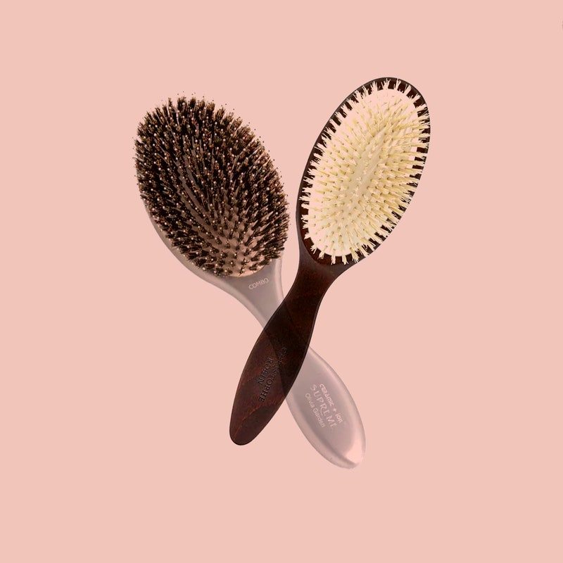 Boar-bristle brushes from Christophe Robin, Fromm, and Olivia Garden on a pink background