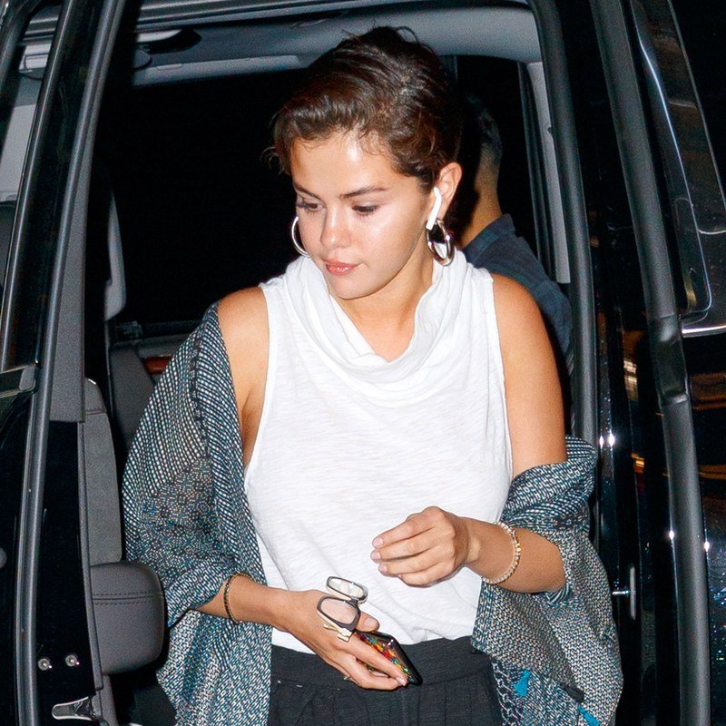 Selena Gomez pairs a mussed updo with silver hoops.