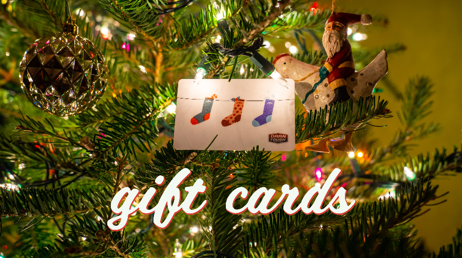 A gift card with socks pictured on it, nested in a Christmas tree