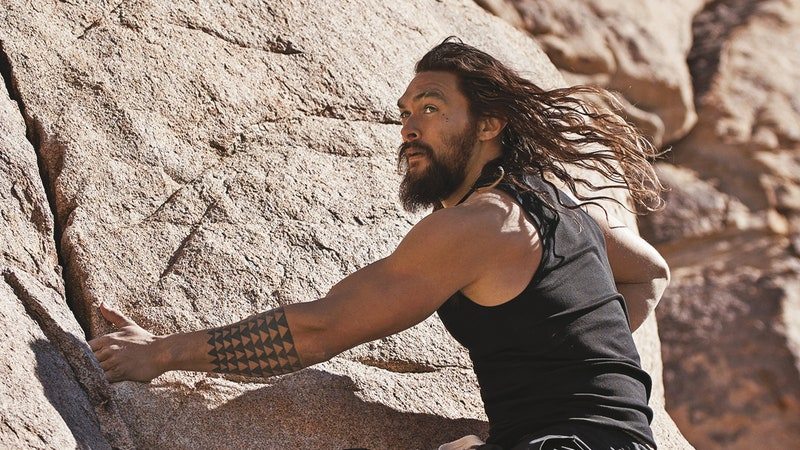 jason momoa rock climbing with hair flowing in the wind